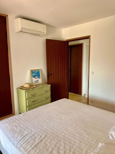 Chambre double climatisée avec commode verte et volets en bois