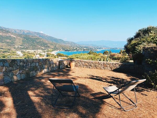 Panorama sur la plage de Sagone et le golfe depuis le jardin de la villa, avec transats
