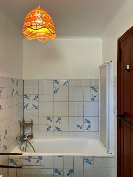 Salle de bain avec baignoire et carrelage à motifs bleus