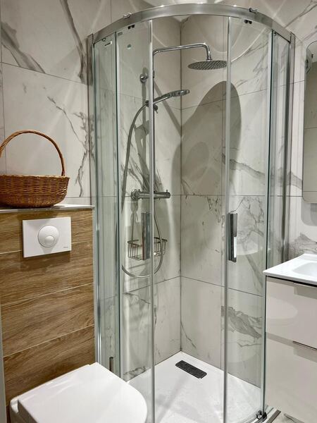 Salle d'eau de la villa avec douche d'angle et faïence effet marbre