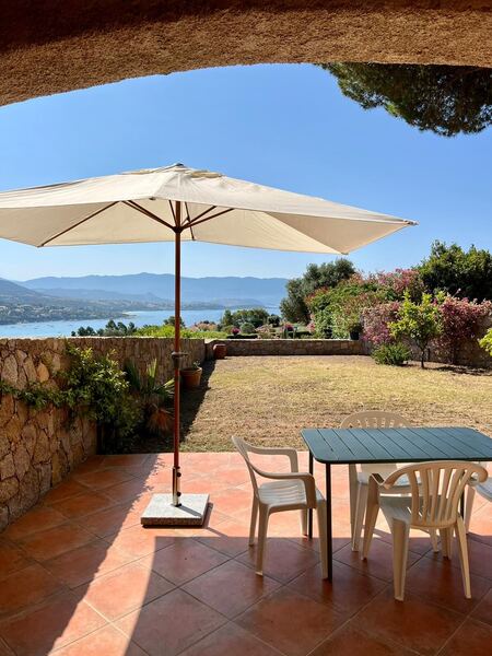 Terrasse de la villa de Sagone avec parasol, table et vue sur le golfe