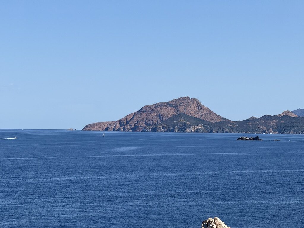 Le promontoire du Capo Rosso vu depuis la mer, avec sa tour génoise au sommet