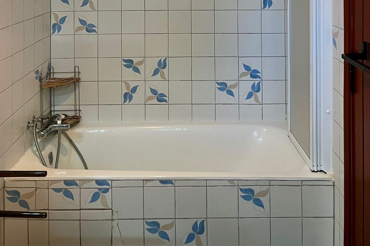 Salle de bain avec baignoire et carrelage à motifs bleus